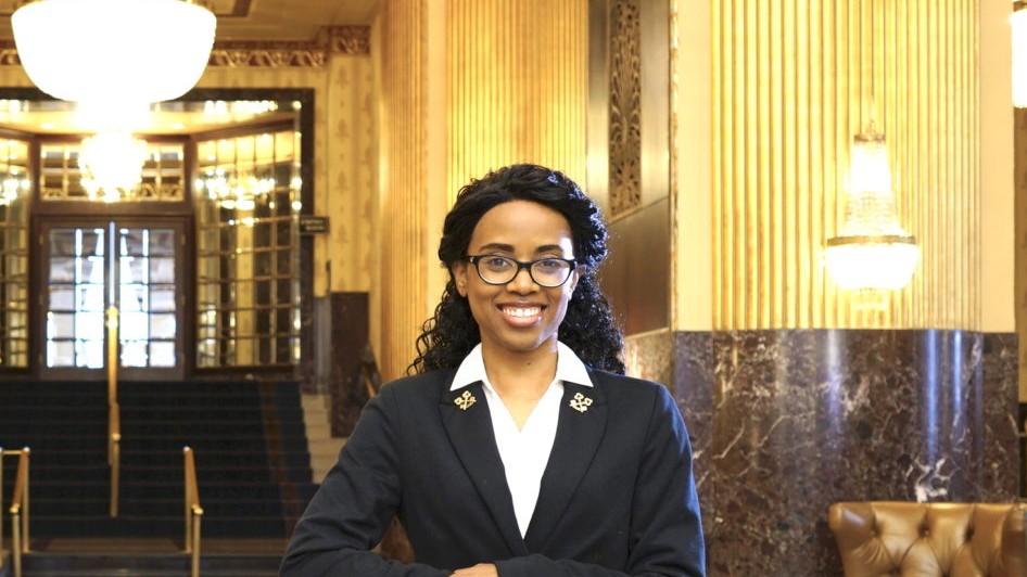 A Les Clefs d'Or concierge stands ready to assist guests in an ornate hotel lobby.