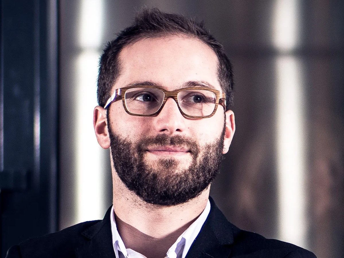 Émilien Boutillat, cellar master, stands confidently in a winery, reflecting his hands-on winemaking background.