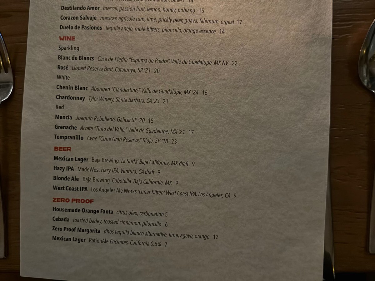 A menu from Broken Spanish Comedor displays a selection of wines, beers, and zero-proof drinks, with prices listed.