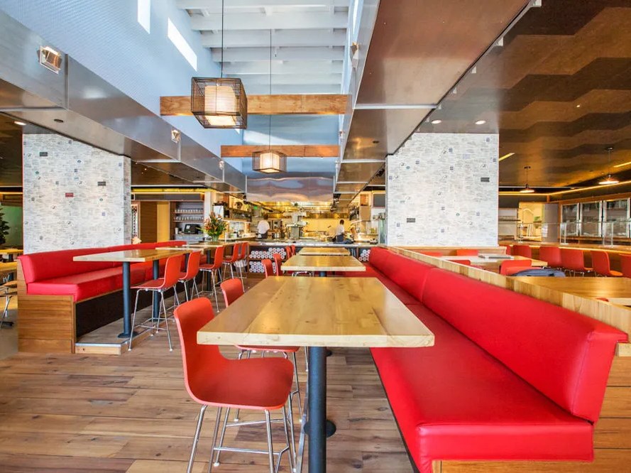 Connie & Ted's modern dining room, featuring red banquettes and light wood tables, awaits guests.