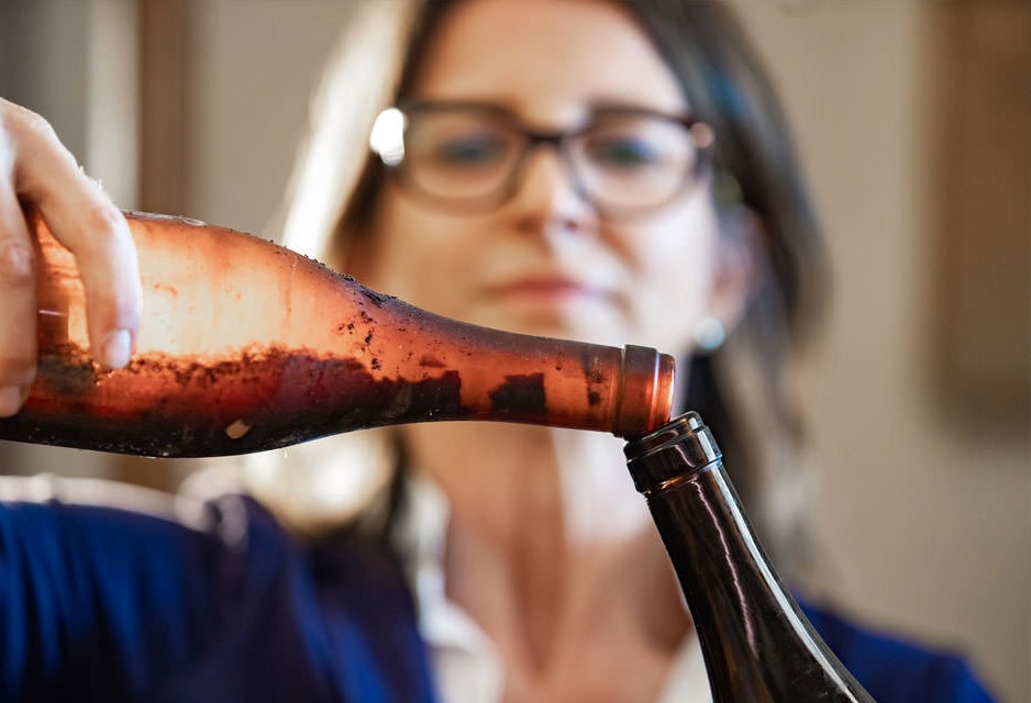 Decanting an aged bottle by hand, sediment intact — from the Emidio Pepe estate's own documentation of its method.
