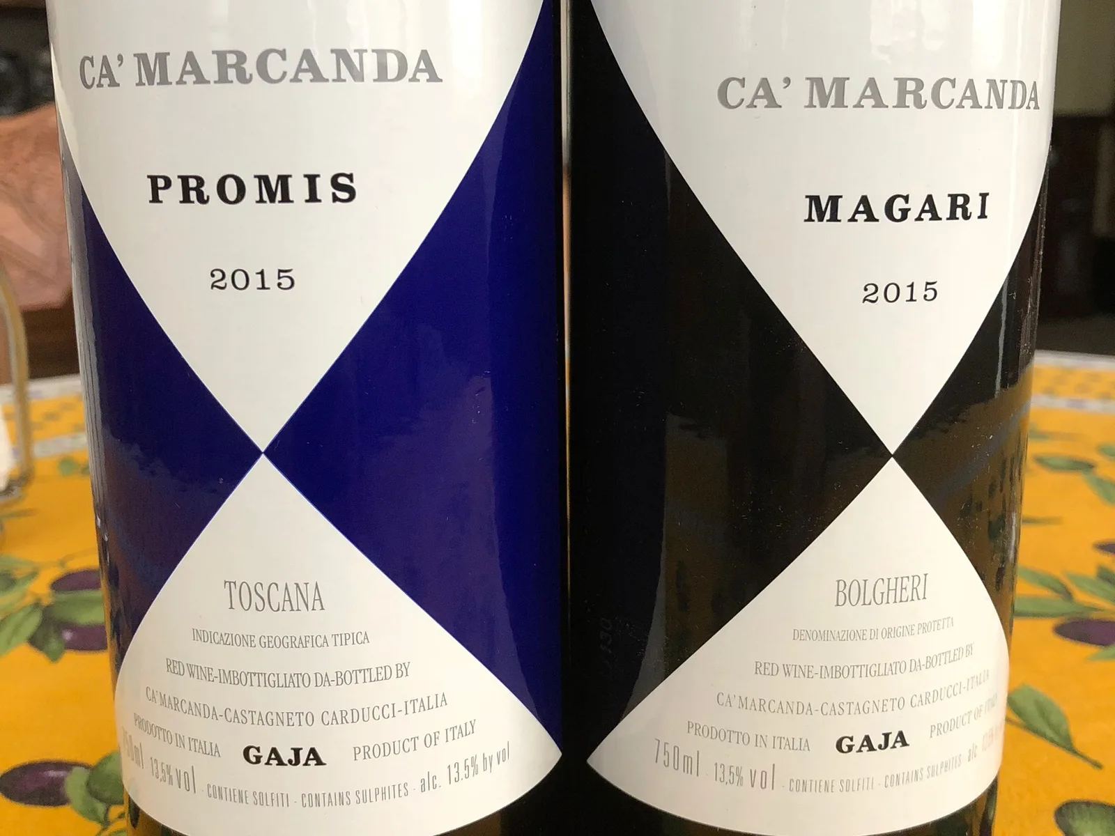 Two wine bottles side by side showing Ca'Marcanda labels for Promis 2015 and Magari 2015, both from Italy and produced by Gaja.
