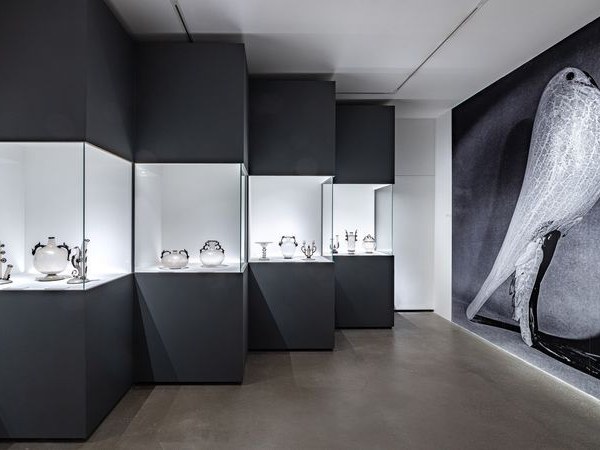 La Stanza del Vetro on San Giorgio Maggiore: Illuminated Murano glass objects against dark walls and a glass bird mural.