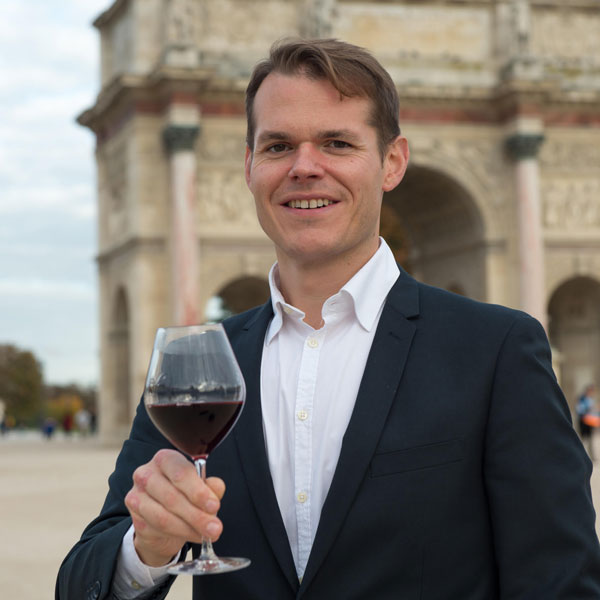 Preston Mohr, a judge for the Gérard Basset scholarship, holds a glass of wine.