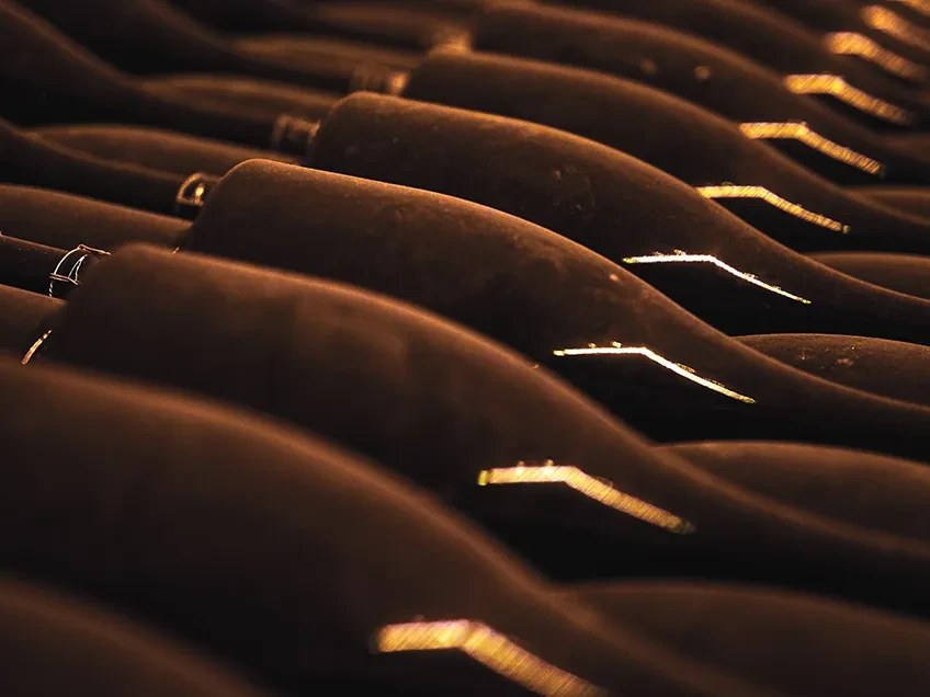 Bottles aging on their sides in the cellar before riddling and disgorgement.