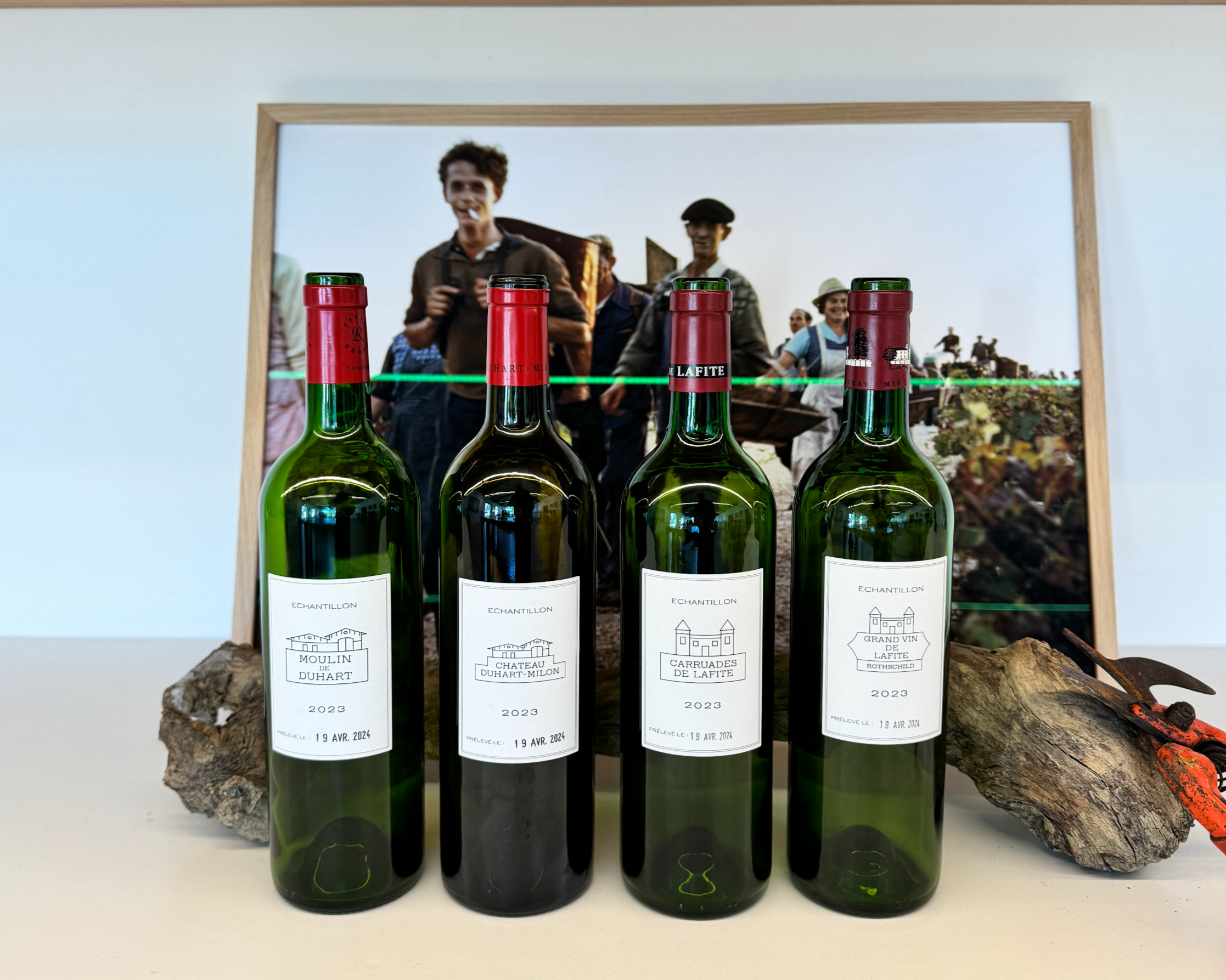 four wine bottles with a picture in the background