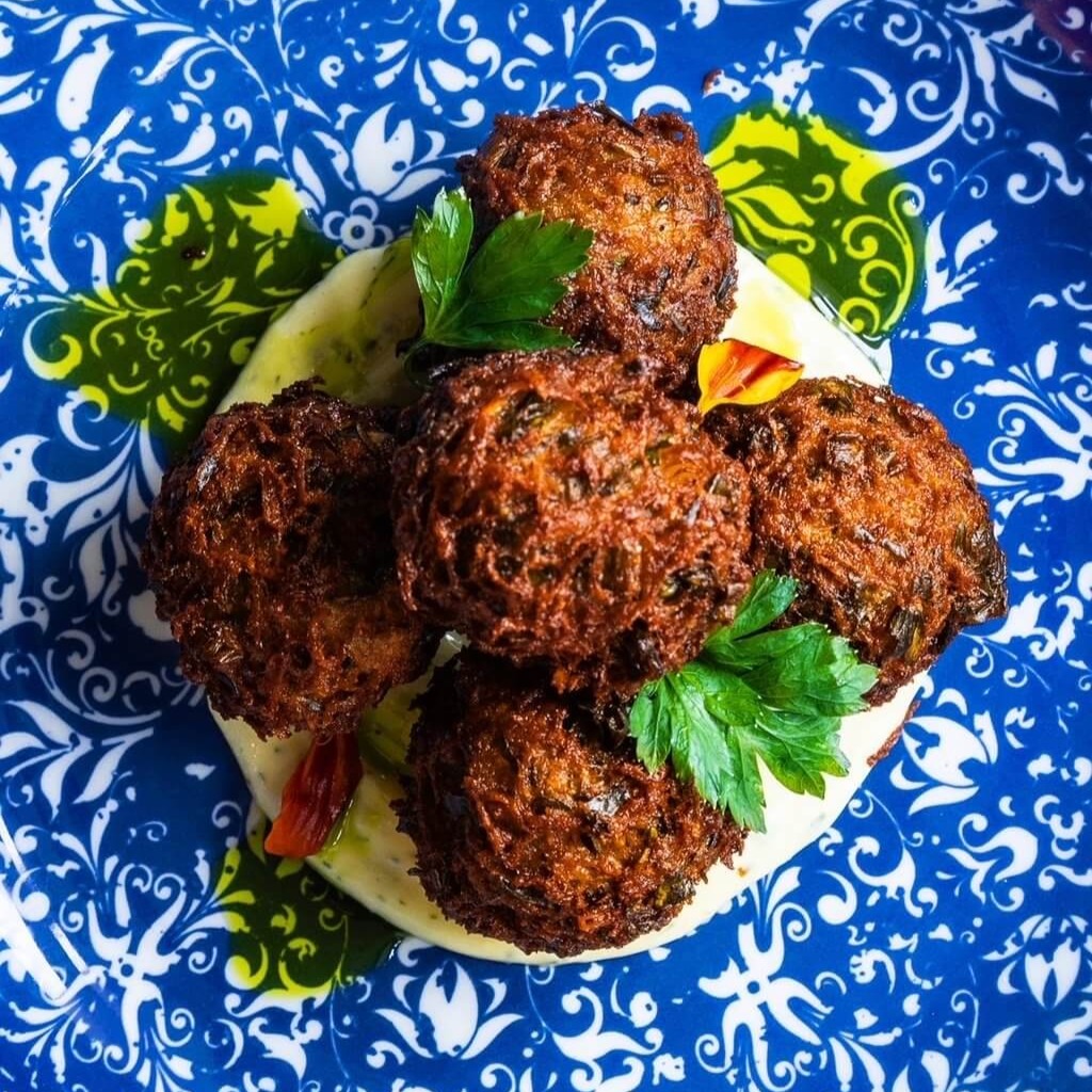 Fried eggplant balls in a green sauce