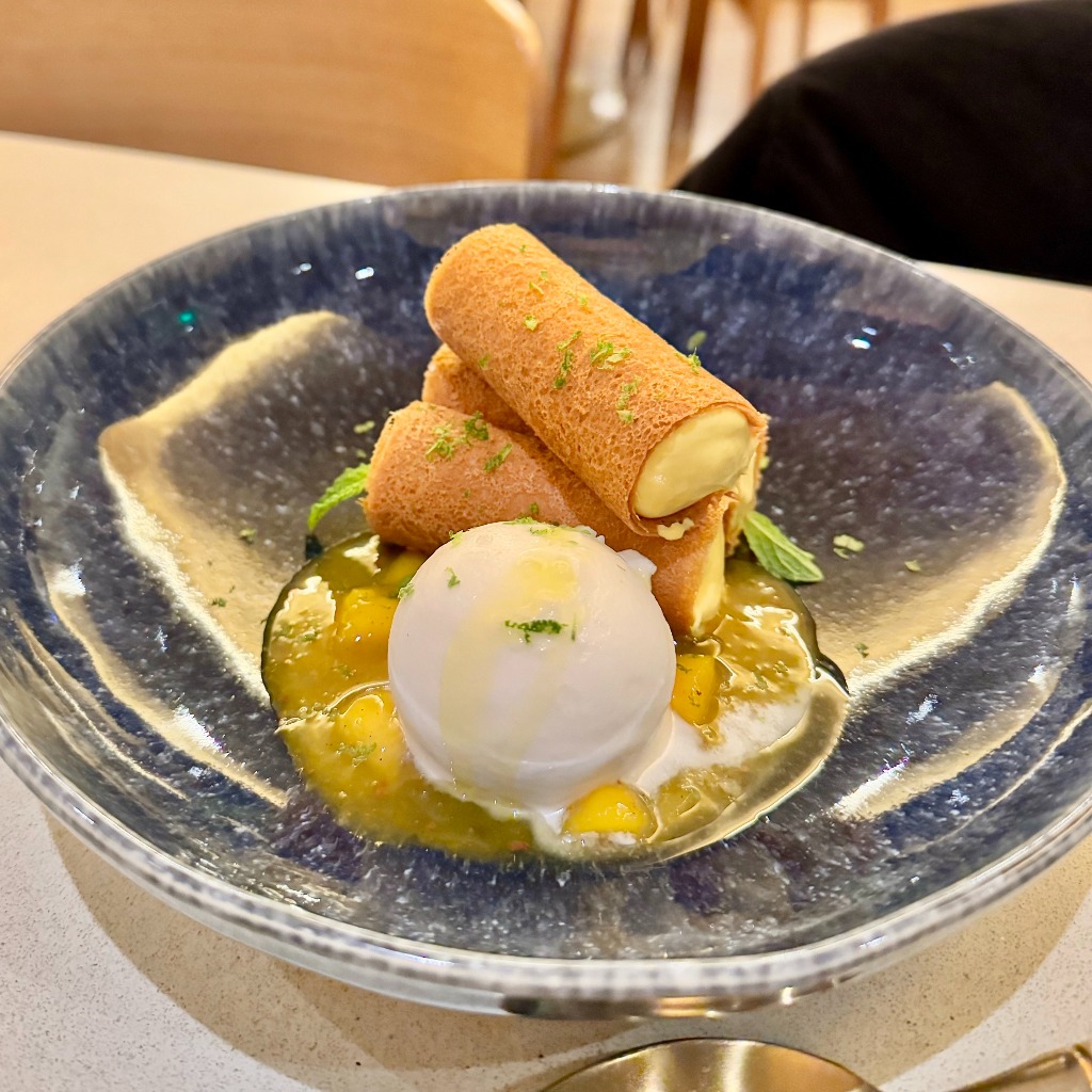 little mango desserts plated in an orange mango sauce