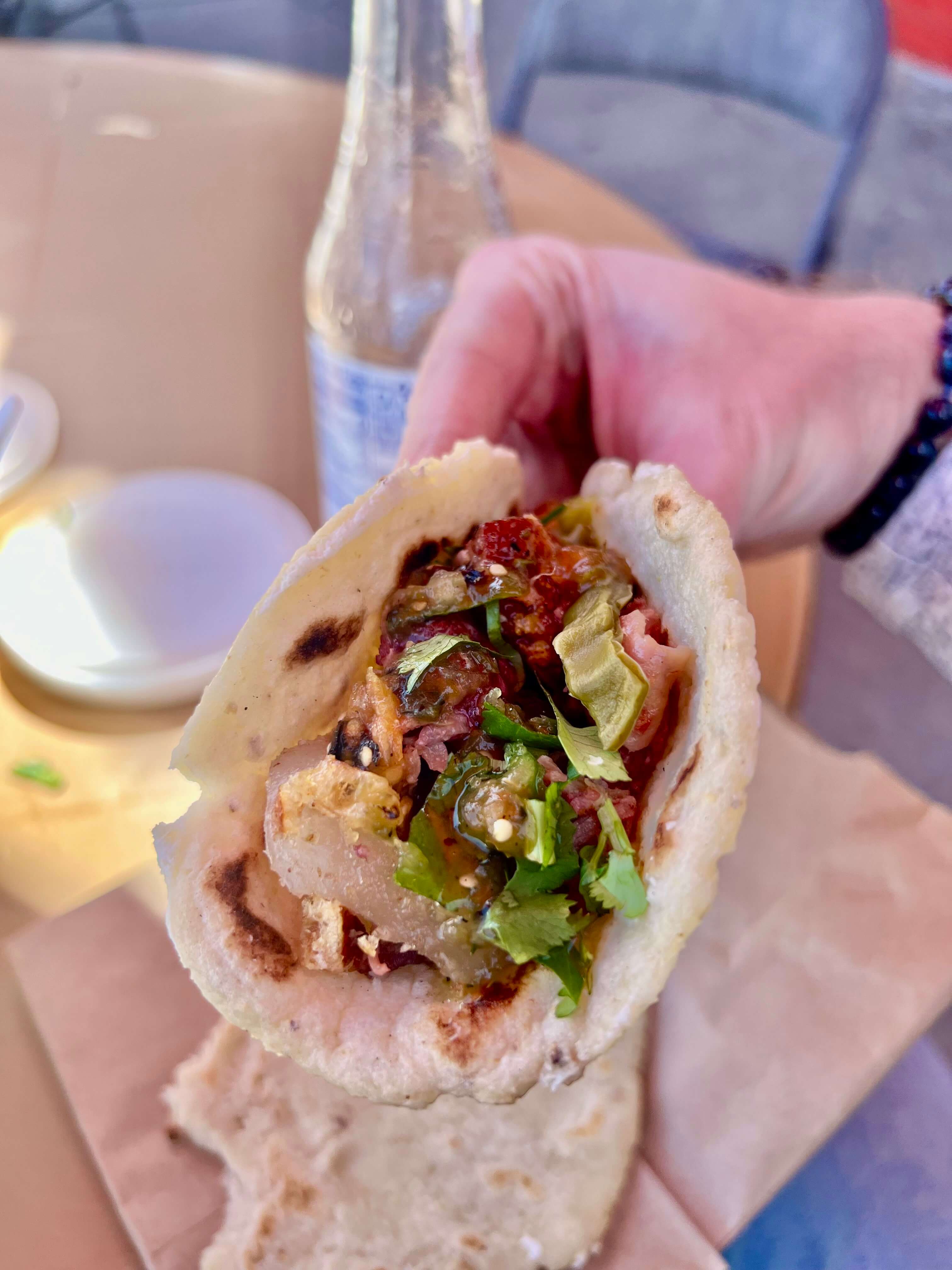 The crunchy carnitas taco from Los Cinco Puntos topped with salsa, cilantro and onions