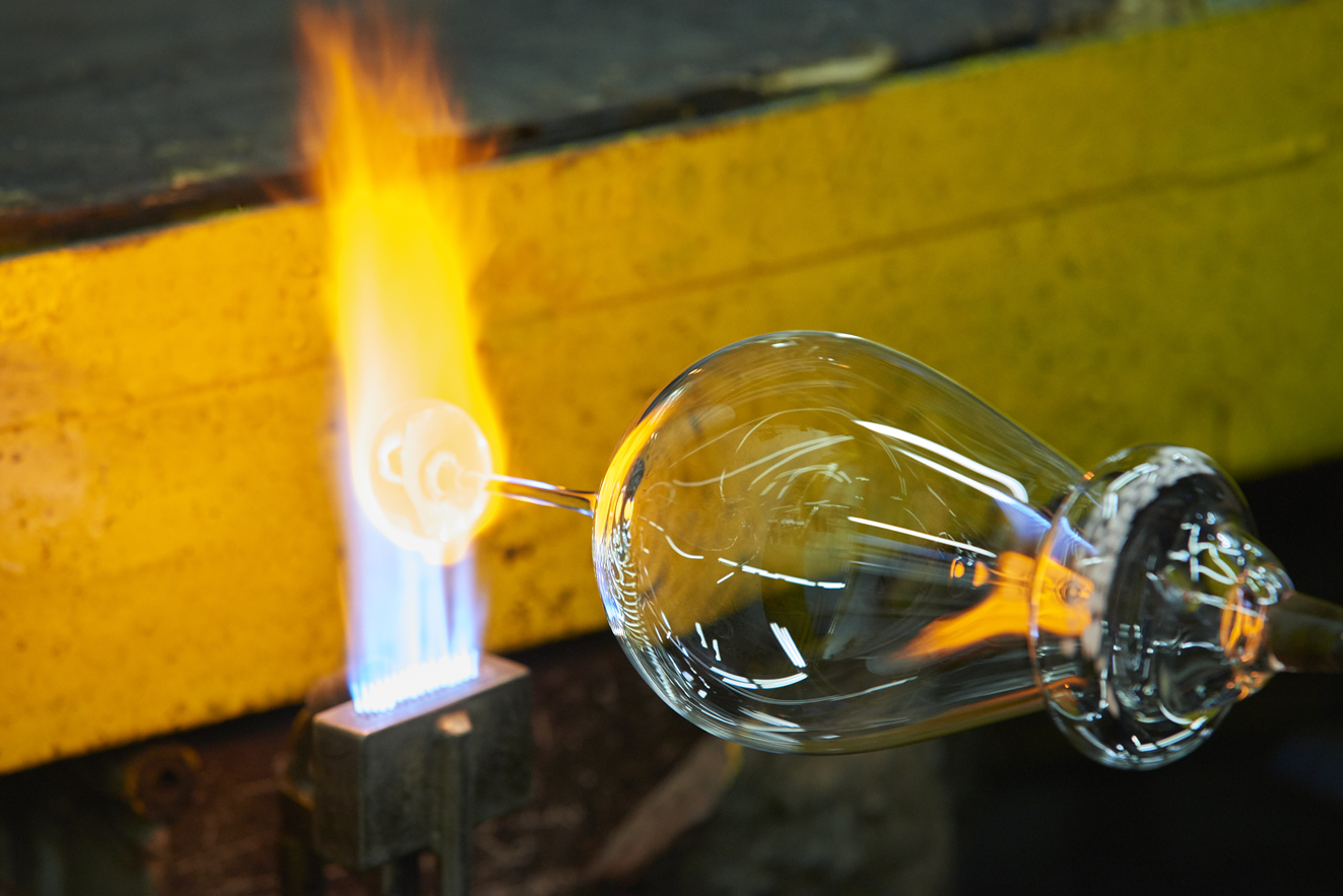 A RONA glassmaker shaping a stemmed glass over a flame